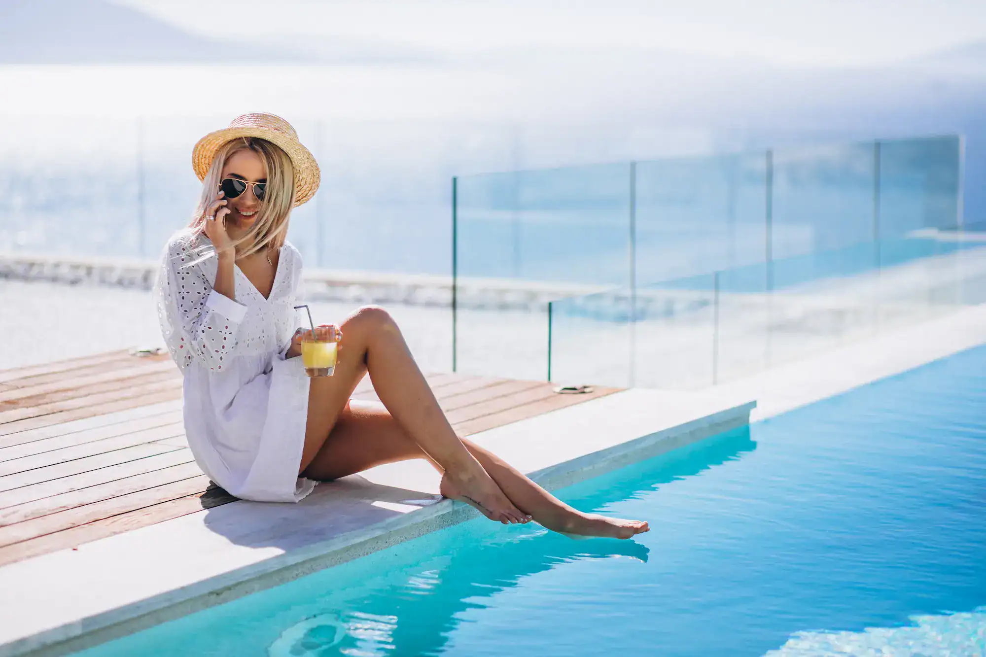 Woman relaxing by a luxury infinity pool overlooking the sea in Cyprus.